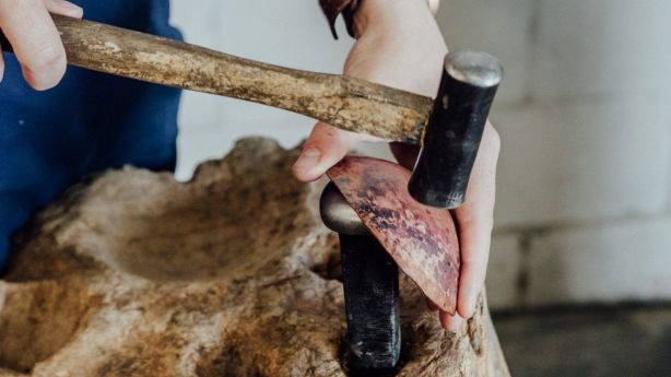 Alison uses the tree stumps in her office when hammering her works. Photo: Andy Mullins