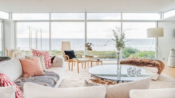 Full-height windows showcase the point-blank water view in the living room. Photo: Sweden Sothebys International Realty