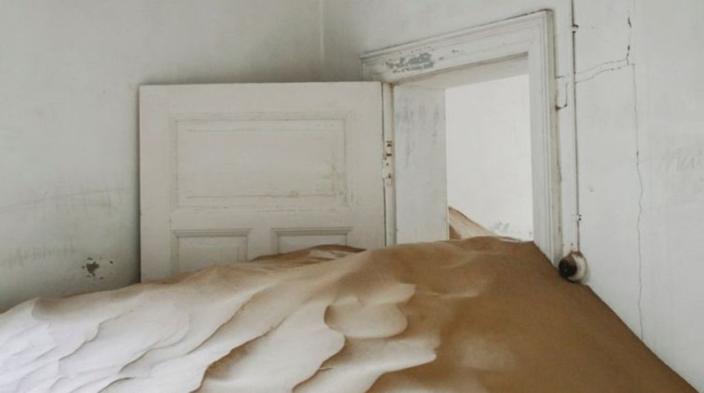 Melbourne artist Emma McEvoy's latest work: a condemned house in Fitzroy, which she has filled with sand. Photo:  Emma McEvoy