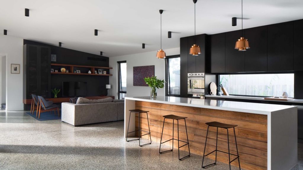 The dark cabinetry and roofing make for a canopy rising above the kitchen. Photo: Emily Bartlett