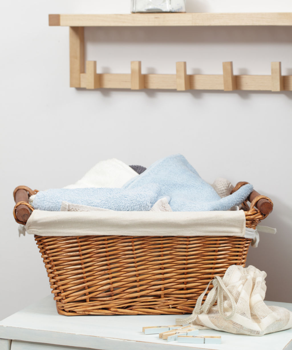 Basket with towels and clothespins in the bag in laundry room