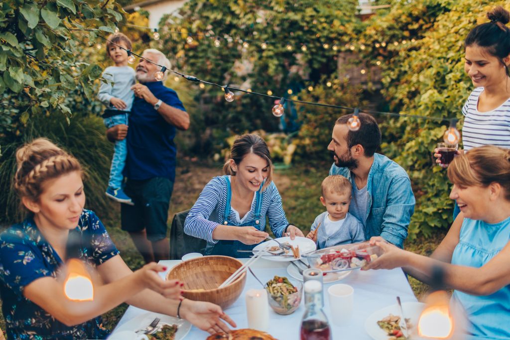Photo of a multi-generation family having dinner outdoors in their back yard Photo: iStock