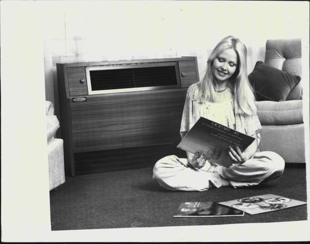 A woman is pictured sitting in front of an air conditioning unit back in 1974.