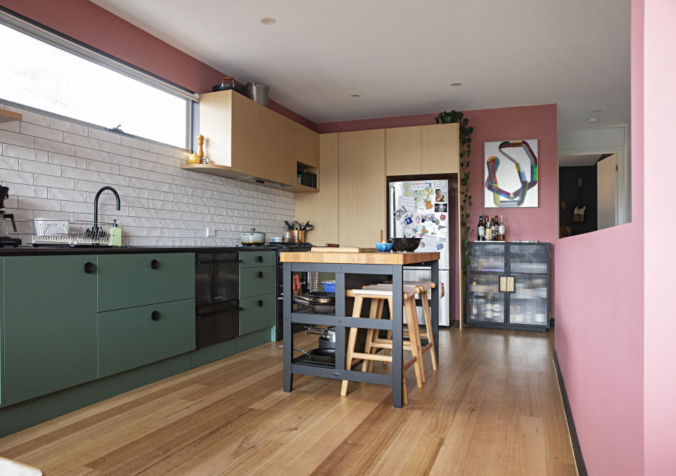 The couple injected their personalities into the home, adding green cabinetry, pink walls, textured tiles and three ovens to the kitchen. Photo: Natalie Jeffcott