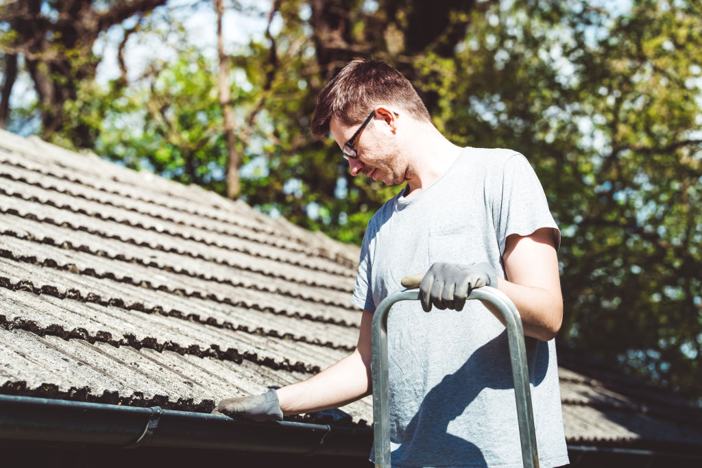 Man cleaning gutters