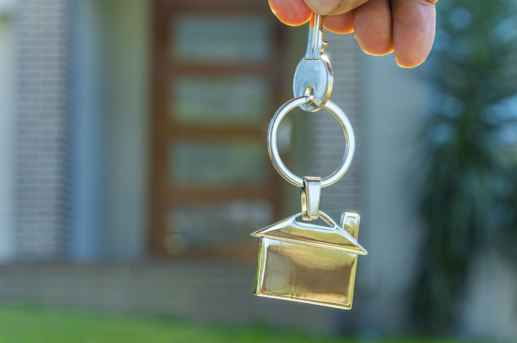 Generic - Hand holding key with house-shaped key ring
