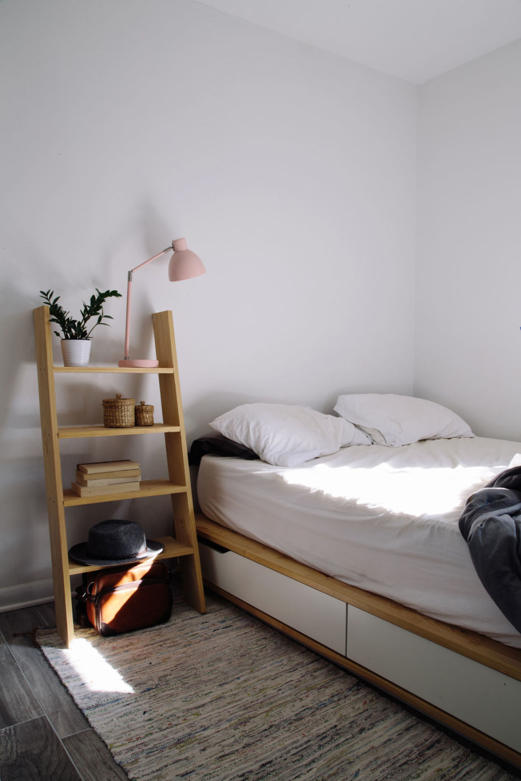 A minimal bed and ladder nightstand