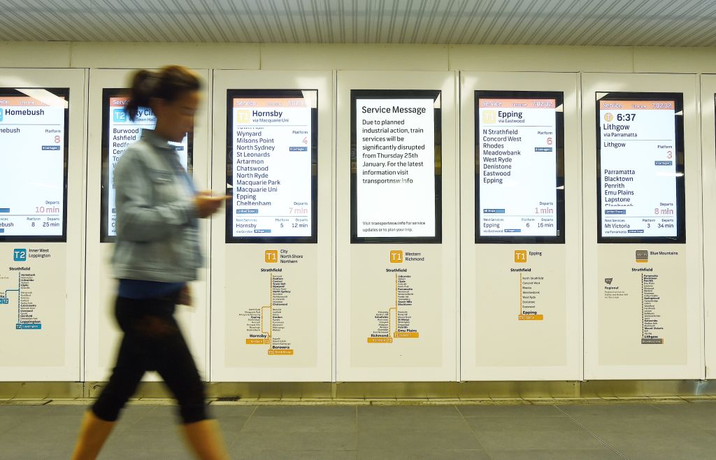 A woman walks past the train schedule information boards at  Strathfield station. Photo: Kate Geraghty Photo: Kate Geraghty