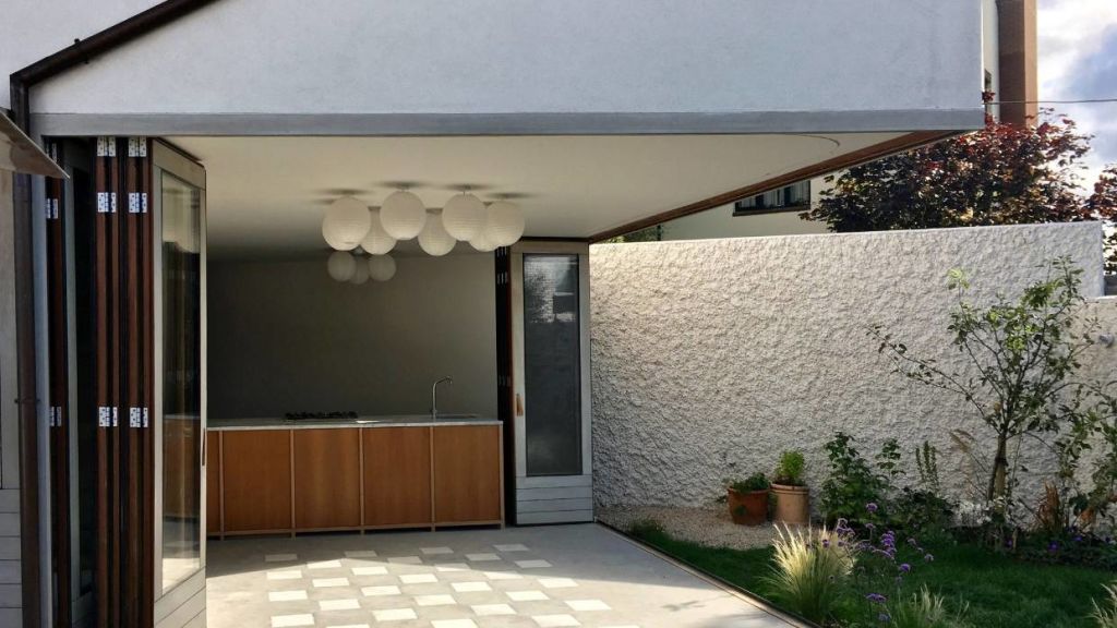 With the side walls peeled right back, the kitchen forms part of the outdoor living area. Photo: David Leech