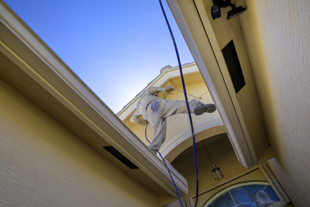 Ideally the painter would be tethered to the roof or building while painting. Photo: iStock.