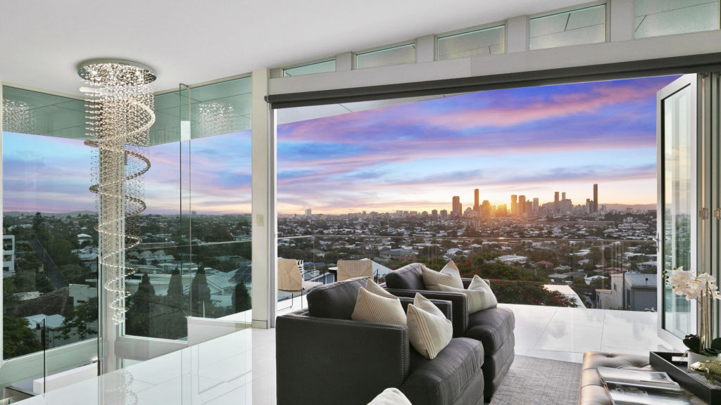 A timber and glass staircase with a chandelier leads you to the top floor. Photo: Supplied