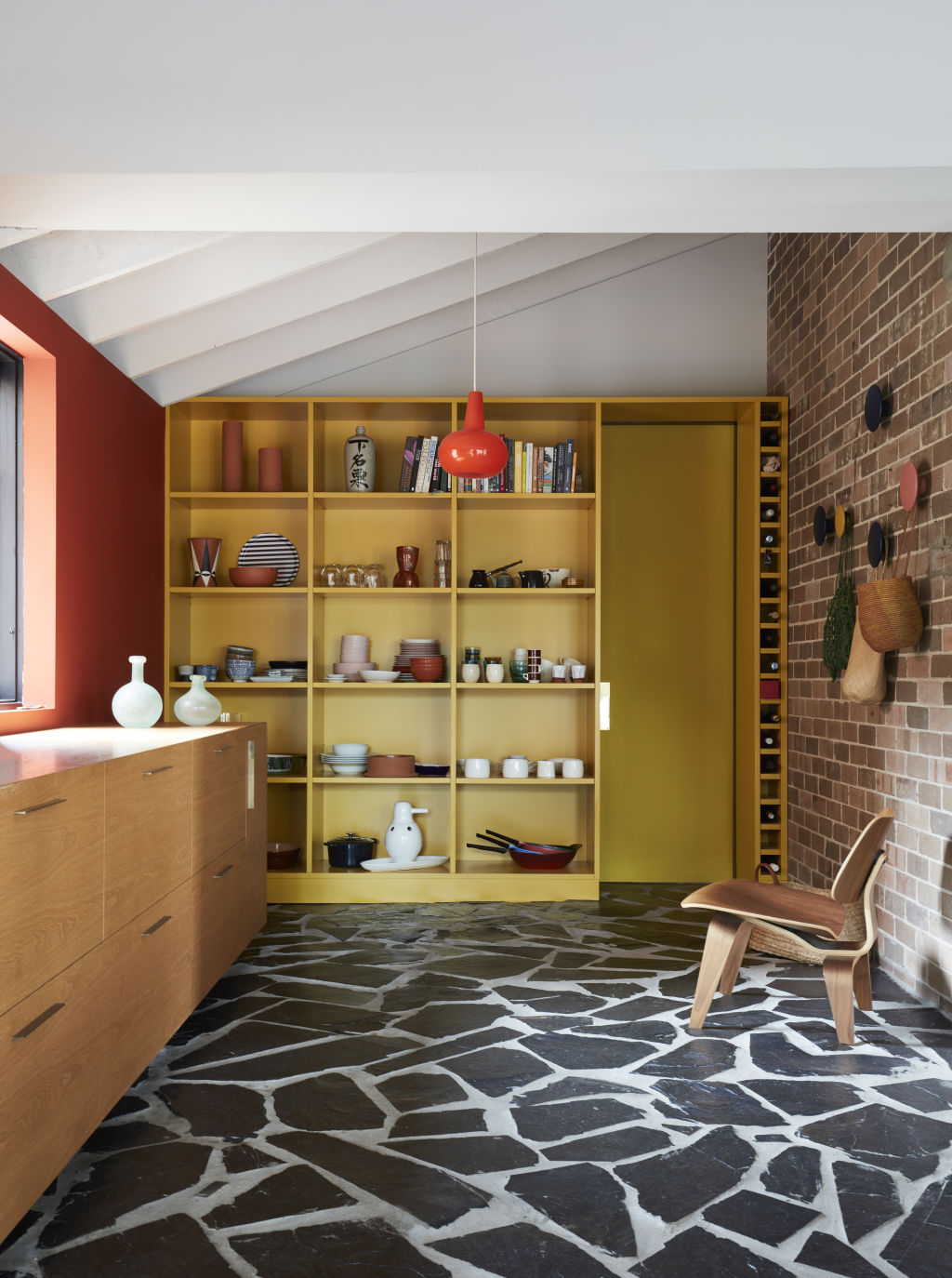 Yellow tinted open-pantry joinery shines in the kitchen. Photo: Prue Ruscoe