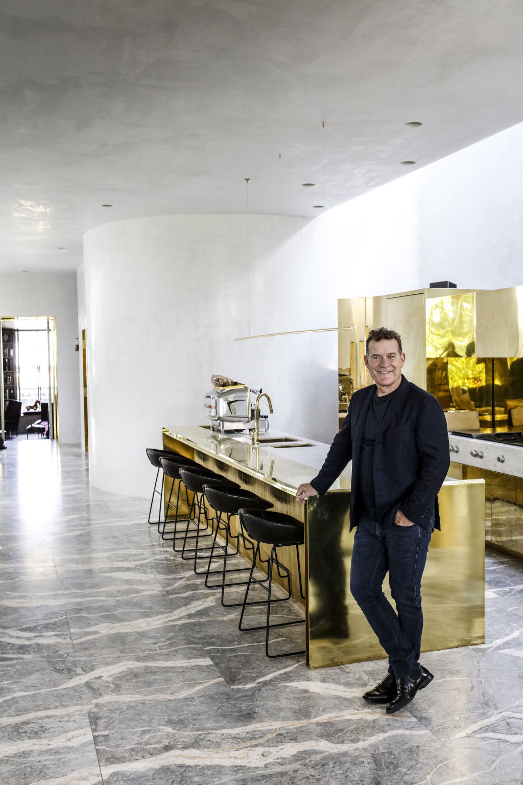 'The furniture and the architecture were conceived as one,' Rob Mills says of the cohesive luxury within his Armadale home, with its sensational brass kitchen. Photo: Julian Kingma