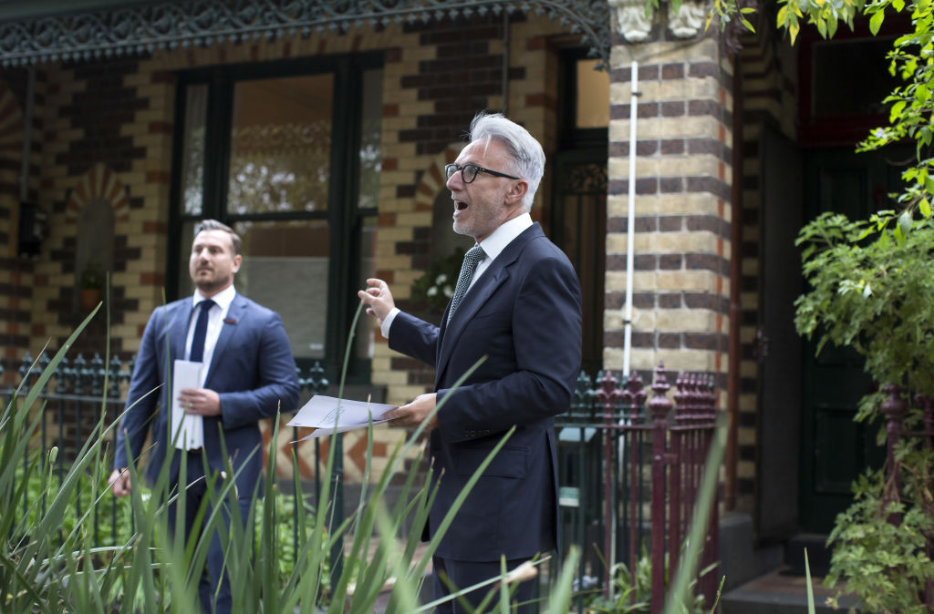 Arch Staver (right) auctions the polychrome-brick terrace. Photo: Stephen McKenzie