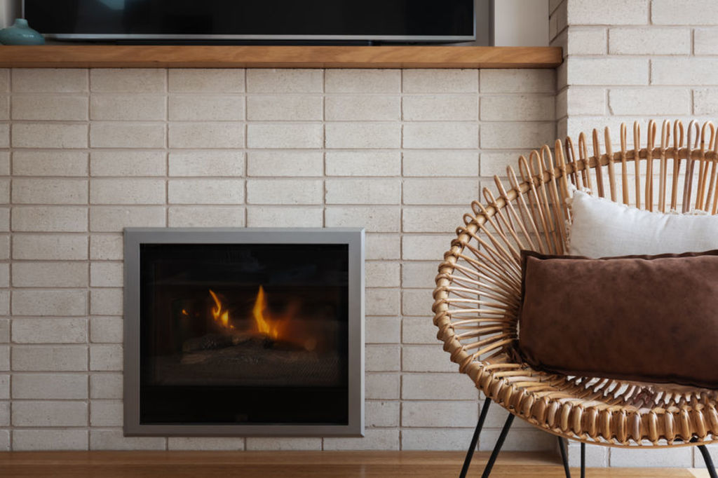 Combustible wood-fired heaters and stylish gas fires are among the ways many choose to keep warm. Photo: Stocksy