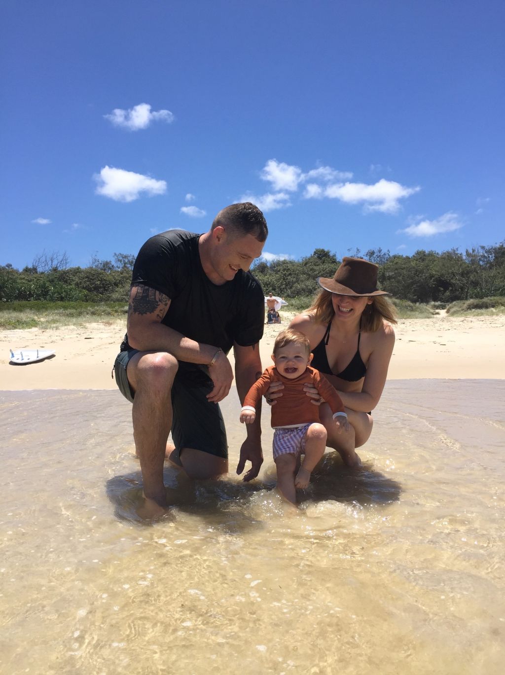 Rugby star Scott Higginbotham with baby Aubrey and wife Madeline at Casuarina Beach. Photo: Supplied