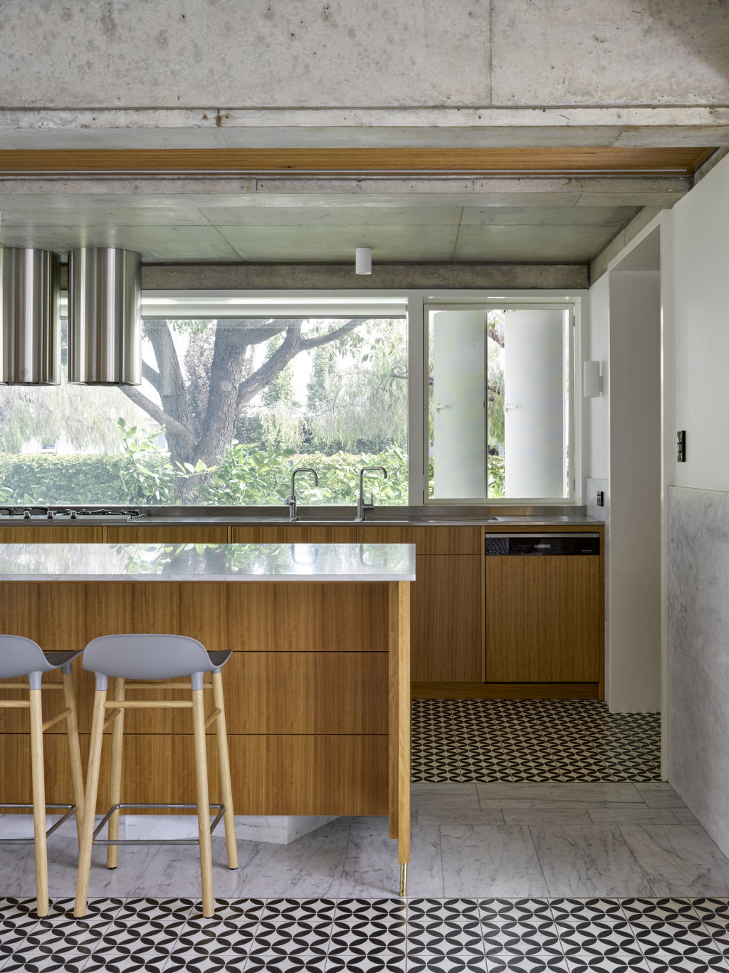 The kitchen is wrapped in Carrara marble and timber veneer cabinetry, with encaustic tiles underfoot. Photo: Christopher Frederick Jones