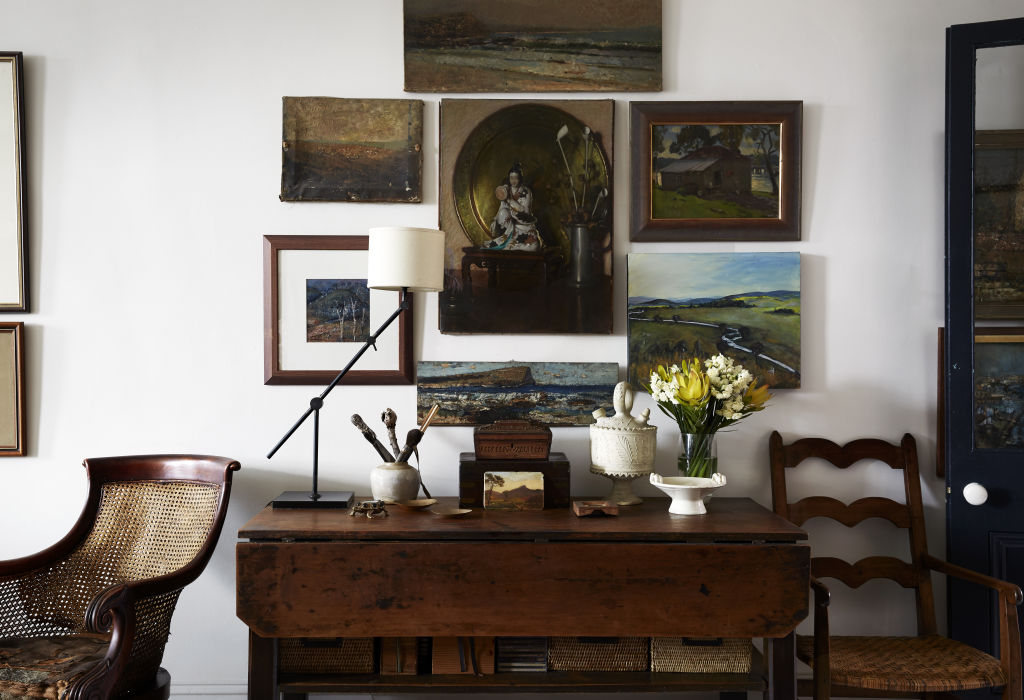 Salon wall of paintings by Tigger alongside those by her great grandfather, Bernard Hall. The studio table and chair are also his. Styling: Annie Portelli. Photo: Caitlin Mills