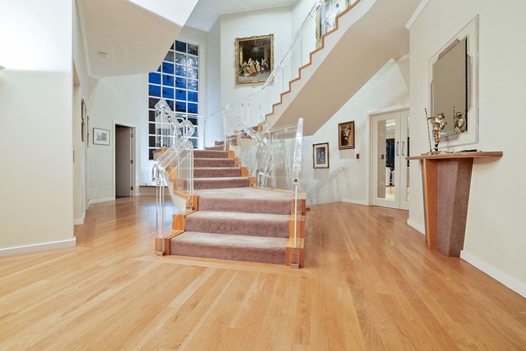 The central staircase is quite the statement. Transparent banisters to add the the already large sense of space the home has. Photo: Supplied