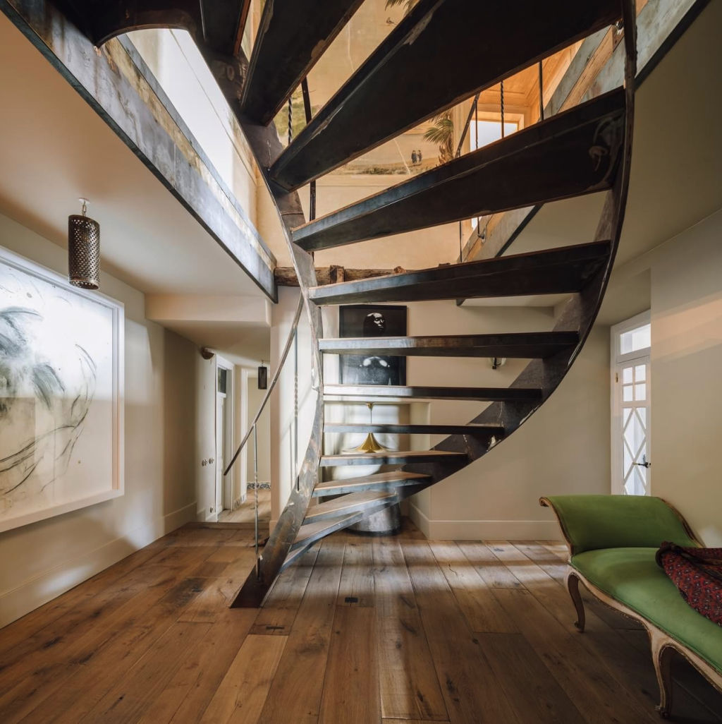 The home's handcrafted wood and metal staircase makes a statement. Photo: Christie's International Real Estate