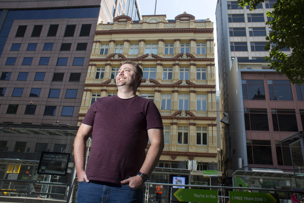 Drew Wood-Davies stands outside the building where he is selling an apartment in Flinders Street. Photo: Stephen McKenzie