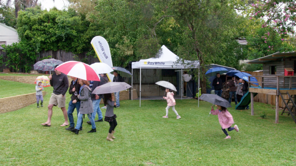 The rain didn't deter auction goers, who were particularly enamoured with the home's large backyard. Photo: Your Domain