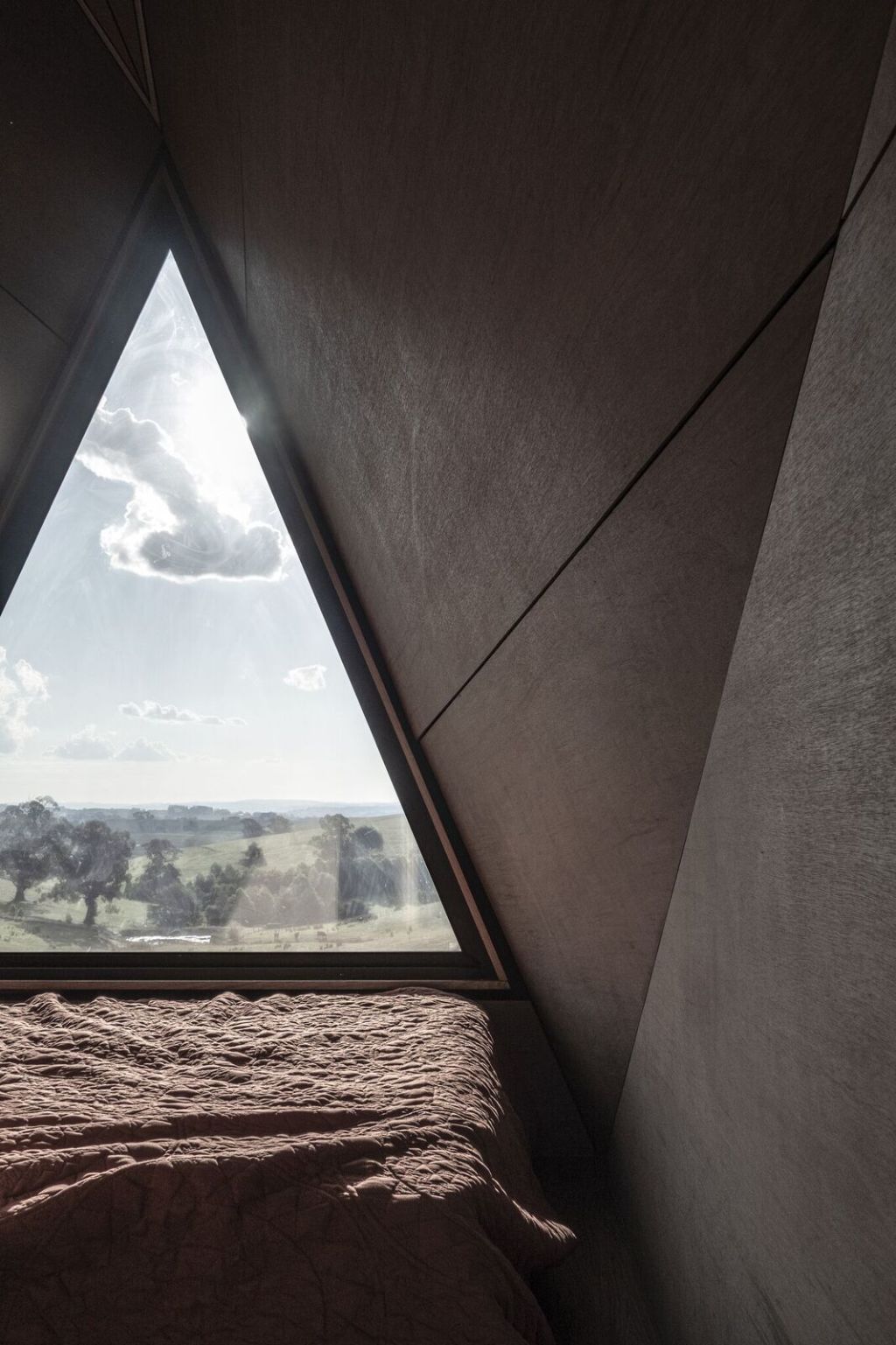 The triangular window at one end allows for ample natural light to filter through. Photo: Ben Edwards