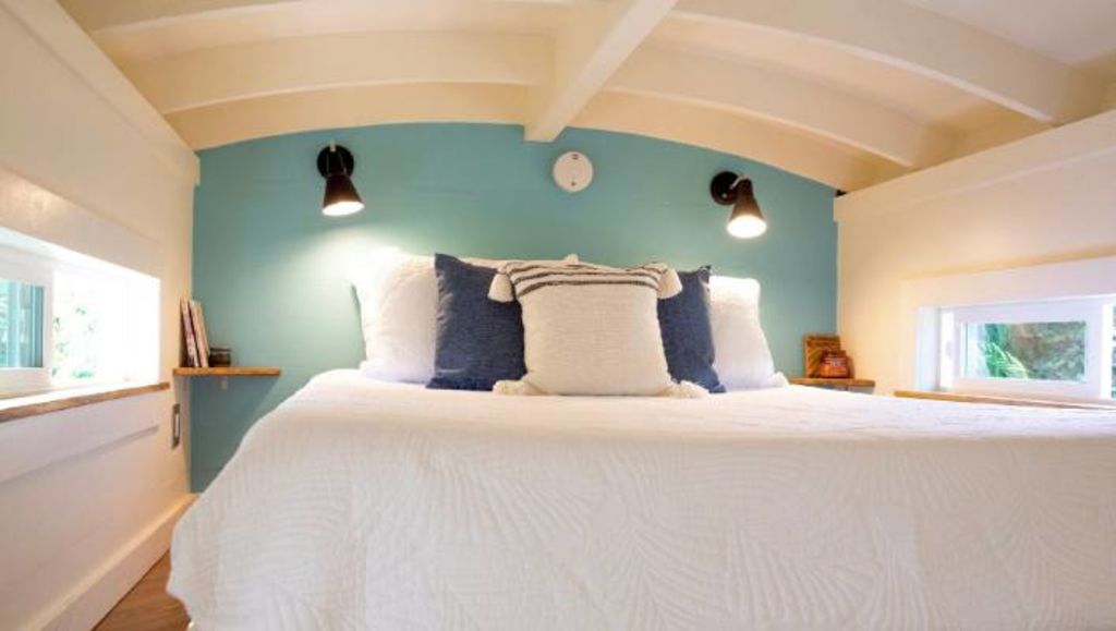 The bedroom sits beneath the curved barrel roof, which Dan Masden says was inspired by the half-pipes on skateboard ramps. Photo: Paradise Tiny Homes