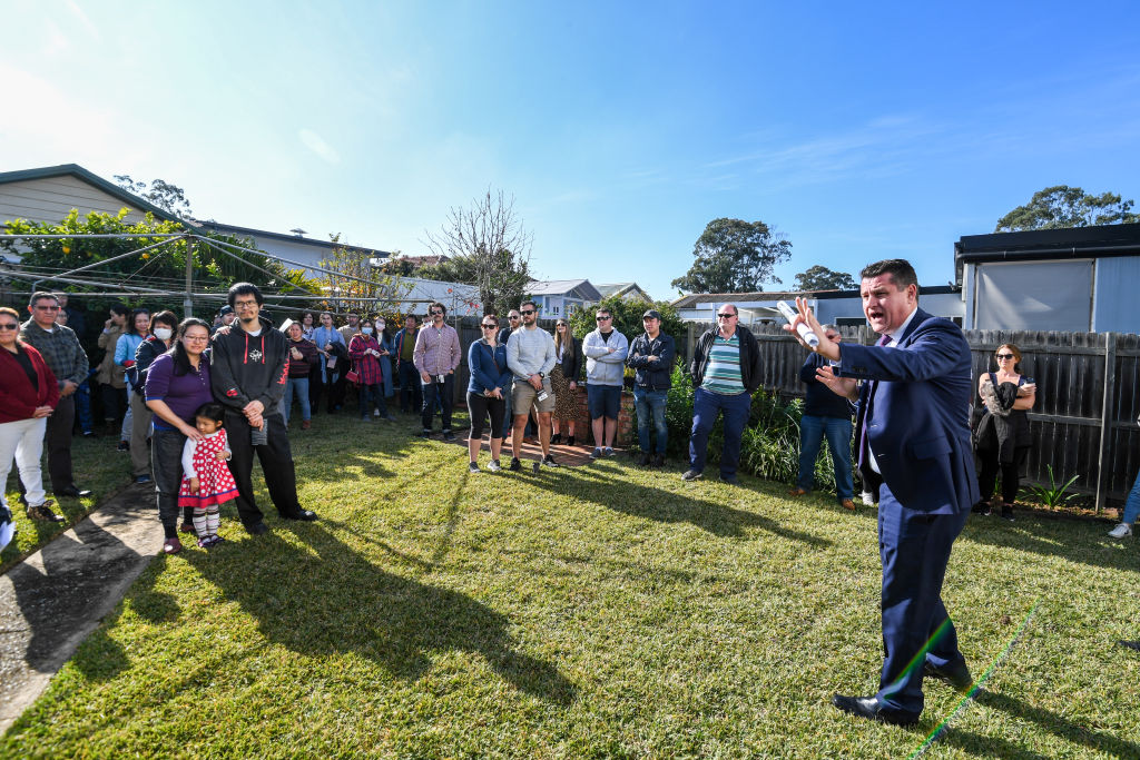 Dozens turned up to watch the three-bedroom house go under the hammer. Photo: Peter Rae
