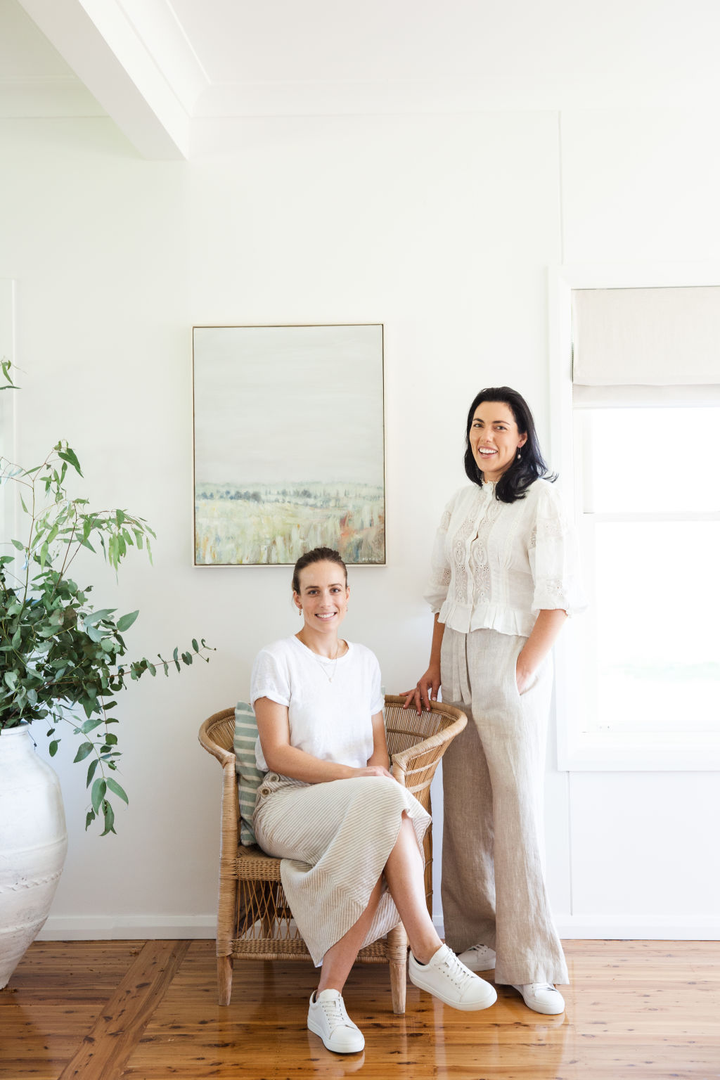 Millie Alison and Katrina Garrett, founders of Australian interior design and decorating company The Design Paddock, with Haze artwork by Kate Durack (from the Walcha Gallery of Art). Photo: Sheri McMahon Photography