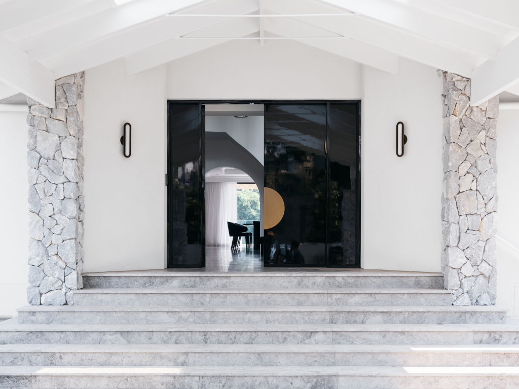 At the entrance, vast glossy black lacquered doors open up onto marble flooring. Photo: Felix Forest