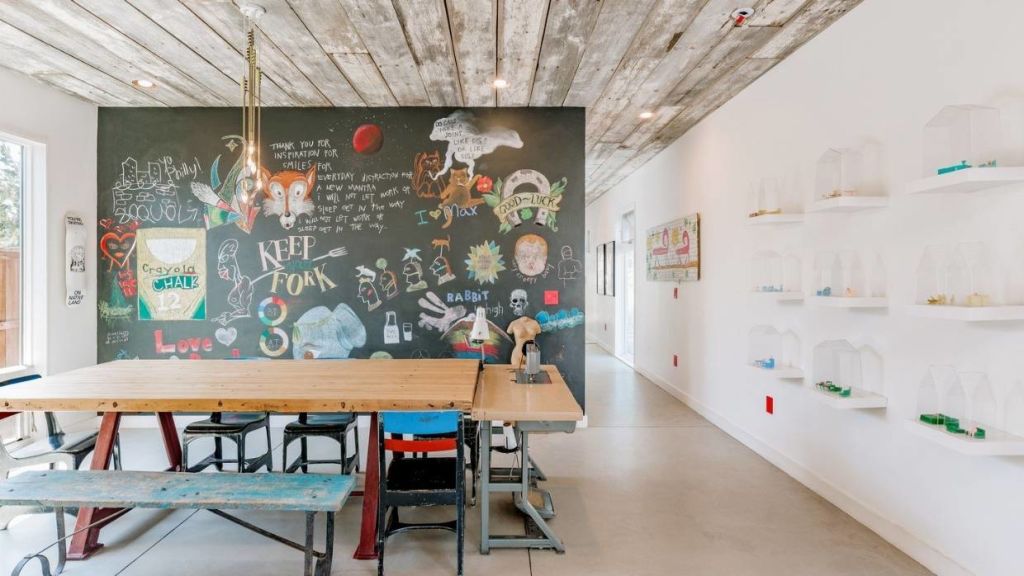 The open-plan kitchen has a floor-to-ceiling blackboard and plenty of shelving to display a collection of art. Photo: Kylie Fits