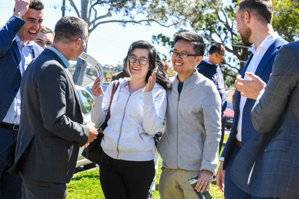 Ray White agent Matt O'Shea (2nd left ) and the selling team from Ray White congratulate the happy buyers. Photo: Peter Rae