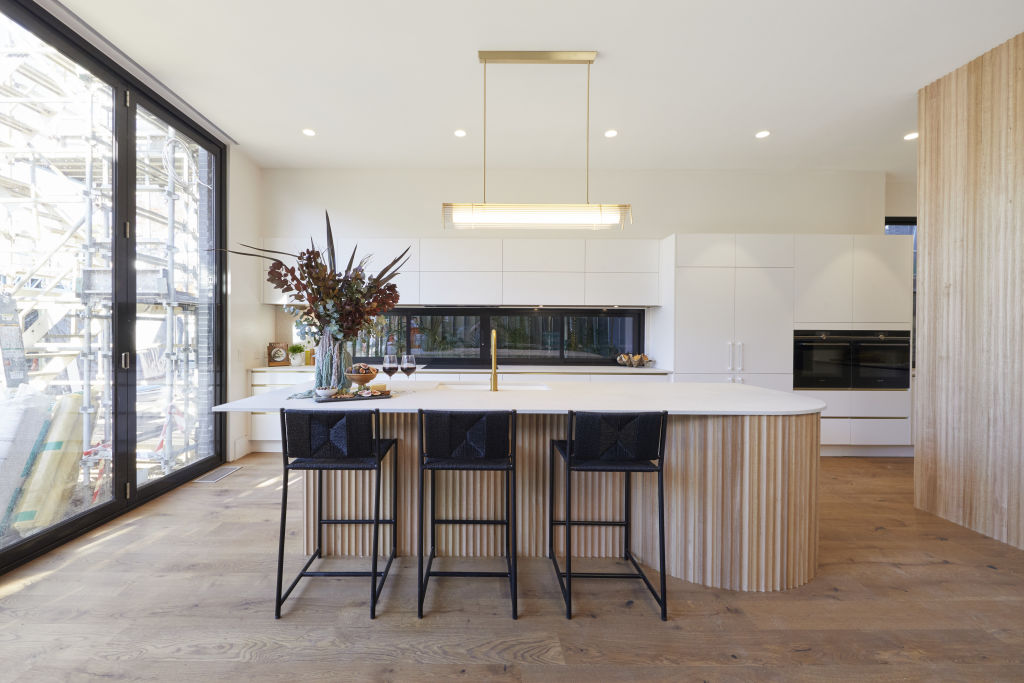 The curved timber and stone kitchen. Photo: Nine.