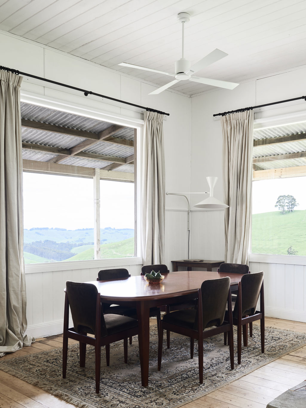 Canvas curtains sewn by Shelley from painters drop sheets. Le Corbusier Lampe de Marseille from Cult. Secondhand dining table, velvet chairs and vintage Belgium rug.  Styling: Annie Portelli. Photo: Eve Wilson