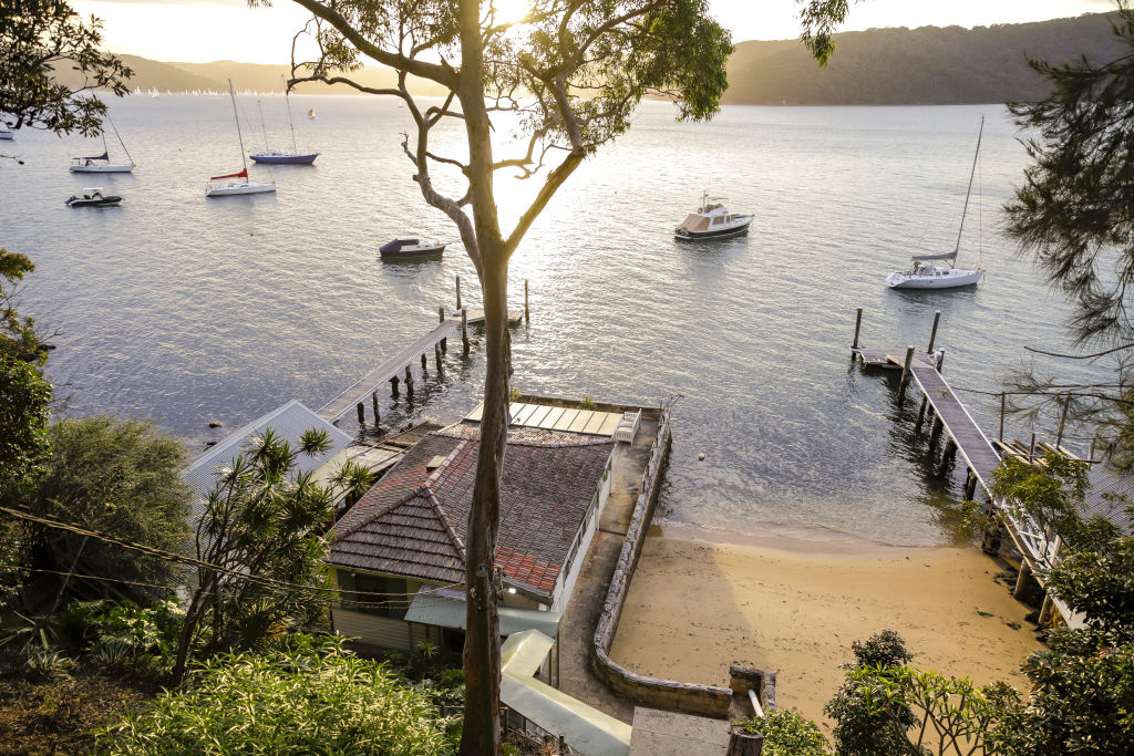 The 936 square metre double block is largely bushland, but with a cottage built out over the water on a sandstone pier.