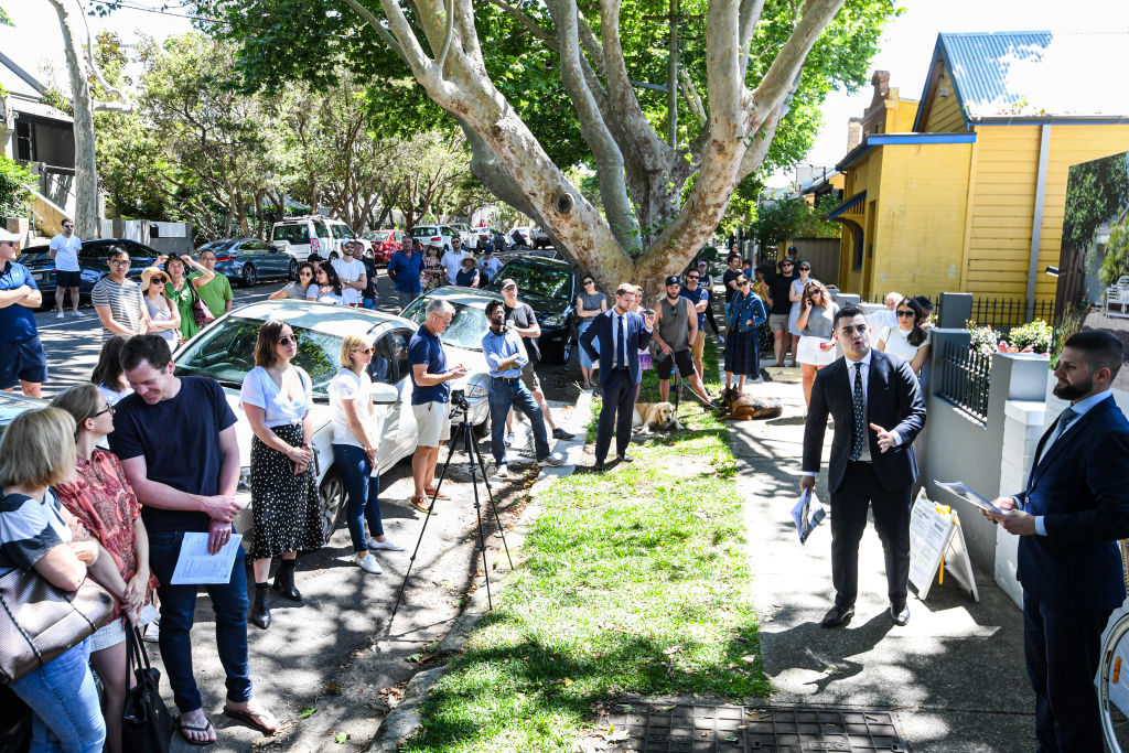 Dozens gathered to watch the auction of the freestanding two-bedroom terrace. Photo: Peter Rae