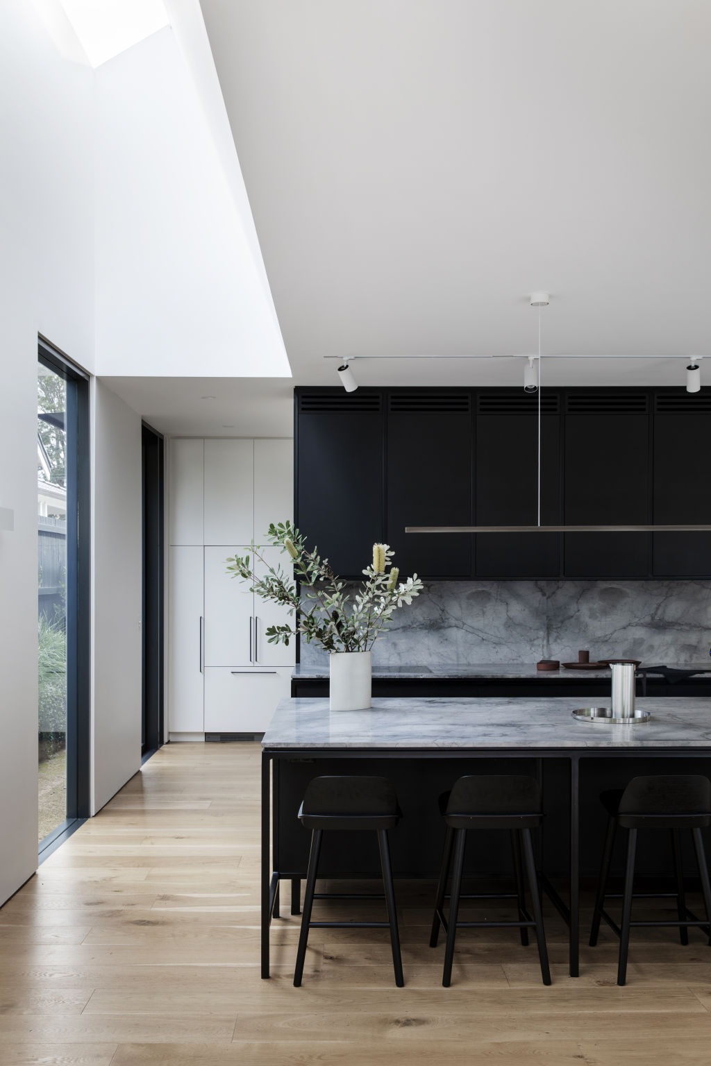 The kitchen is crafted in sustainable black Paperock, (a condensed form of paper) and platinum honed grey marble. Photo: Chris Warnes