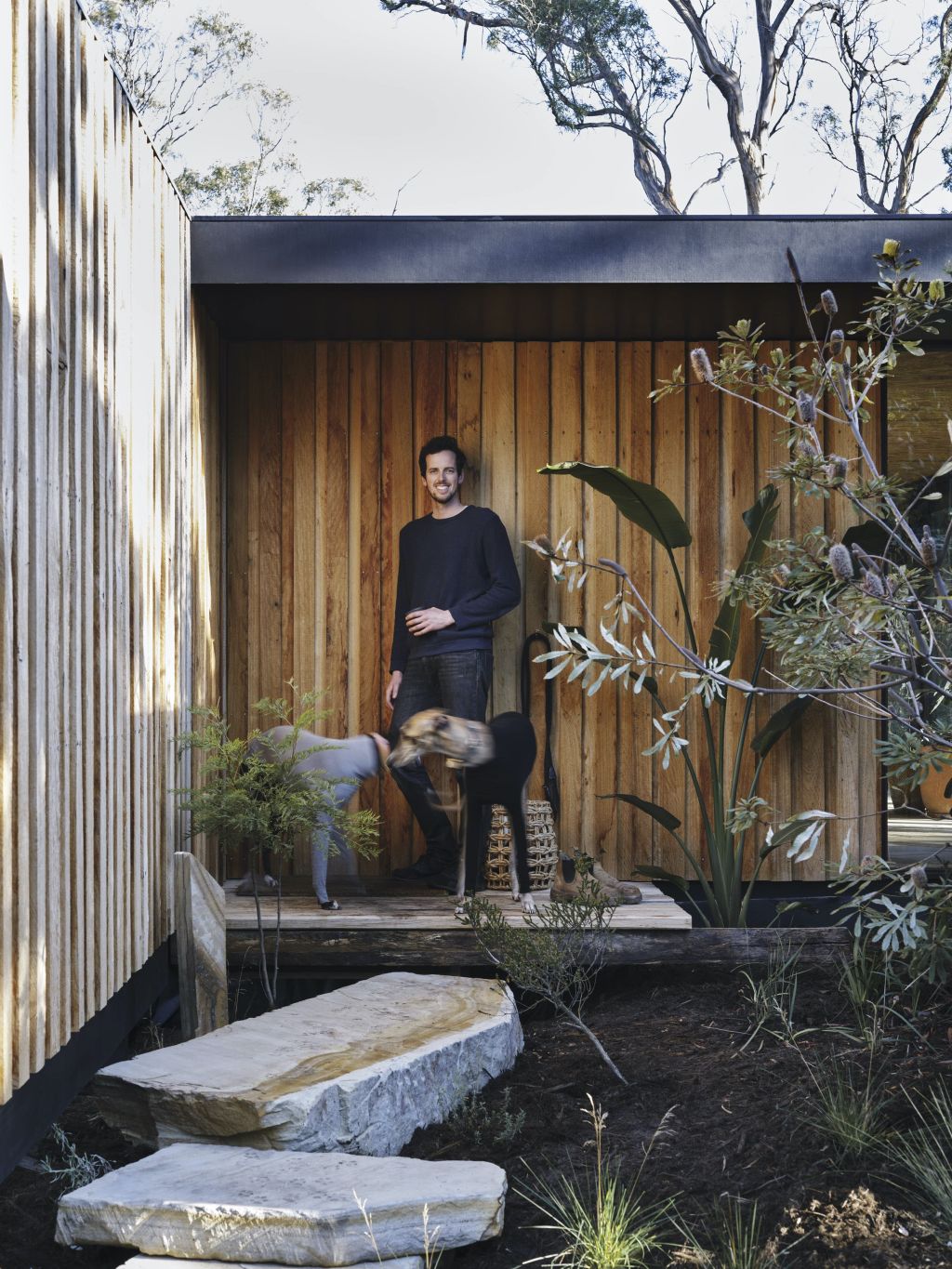 Josh FitzGerald and his rescue dogs Frankie and Rosie at the small house he built in Tasmania.  Photo: Adam Gibson