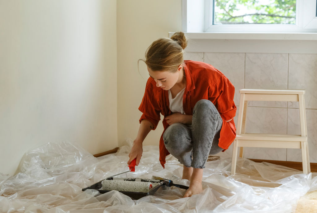 Try your hand at DIY for tasks like painting or removing carpet to save on unnecessary labour costs. Photo: Stocksy