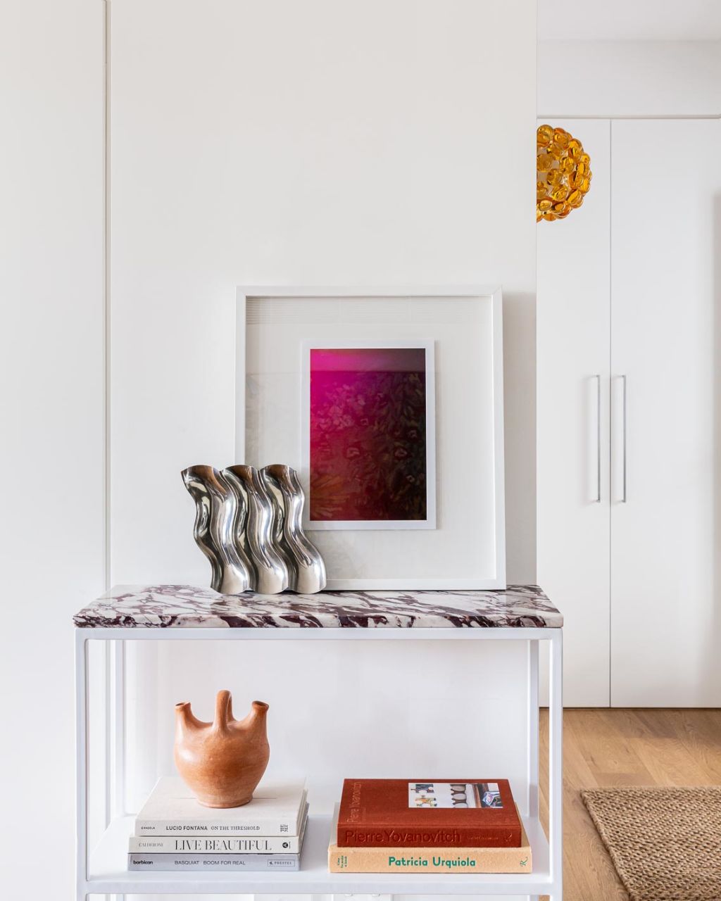 Patricia Urquiola’s Foscarini Caboche wall lights in amber add a pop of colour in the entrance. Photo: Chloe Lambert