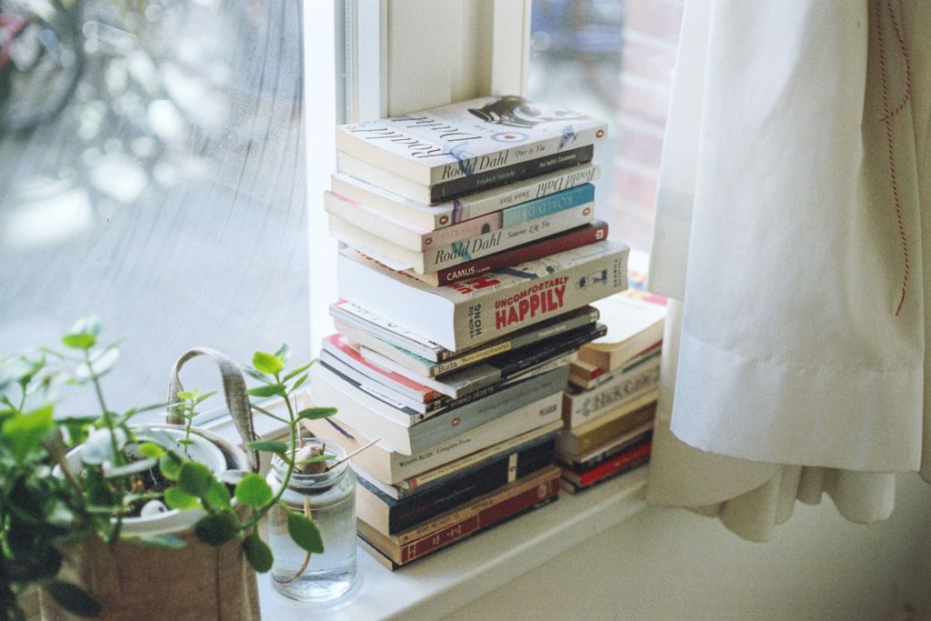 Consider moving books off a bookshelf to create bookish moments around the home. Photo: Unsplash