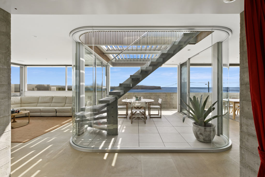 The feature staircase, with its double glazed void and curved structure, makes the home feel more open and connects the three storeys  Photo: Supplied