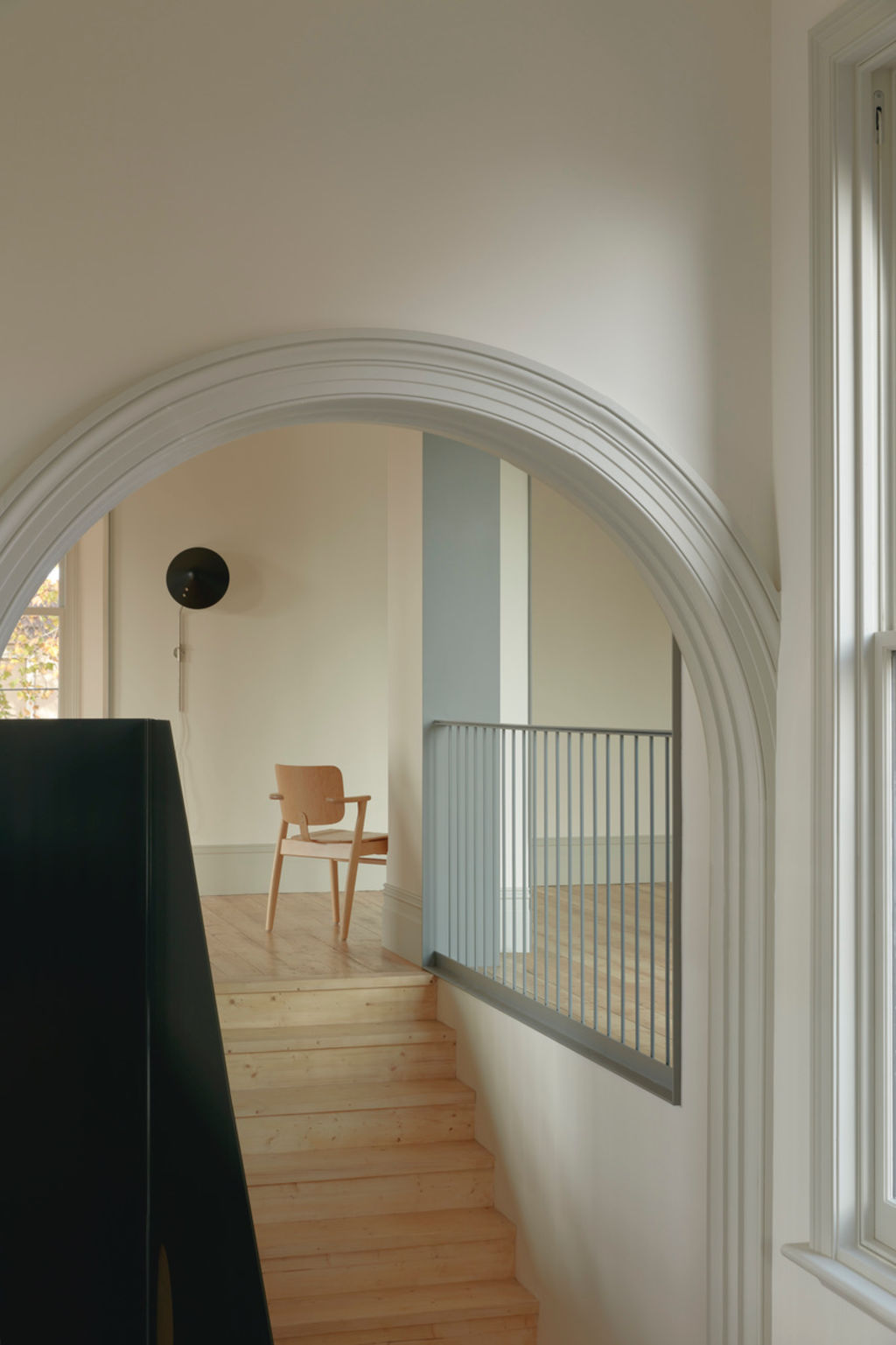 Thick plate steel was fabricated into a statement stair bannister under a Victorian arch. Photo: Tom Ross