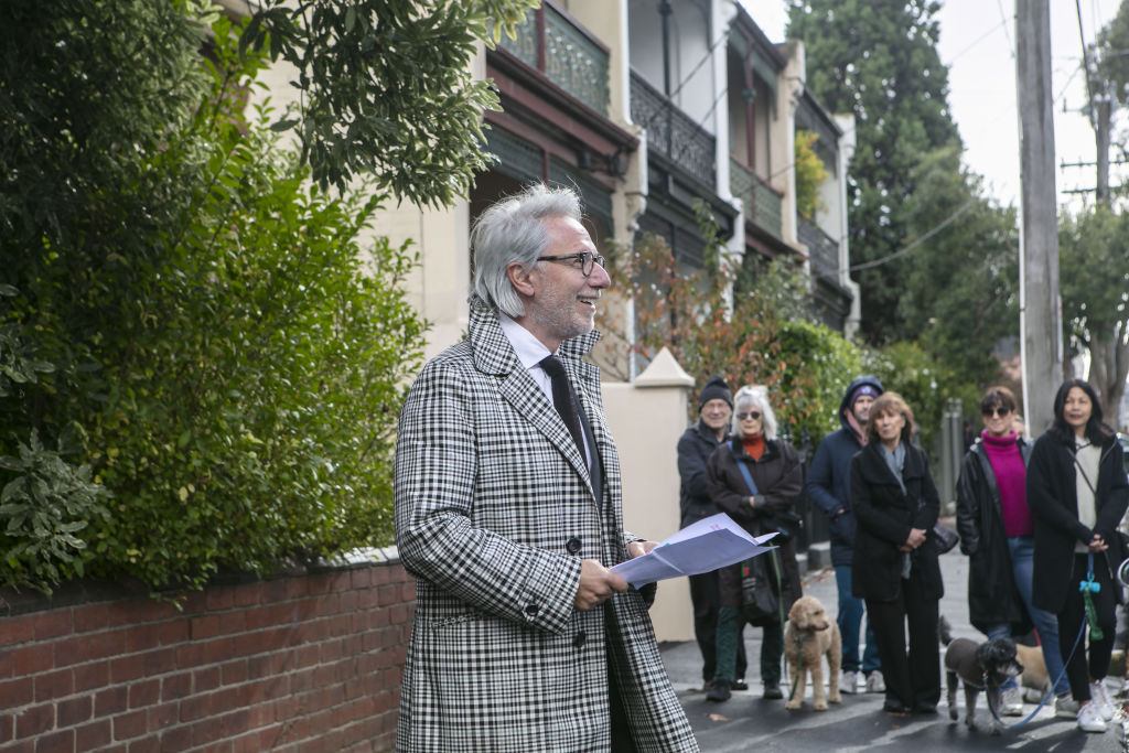 Onlookers watch on as Arch Staver from Nelson Alexander Fitzroy auctions the National Trust-listed home in Clifton Hill. Photo: Stephen McKenzie
