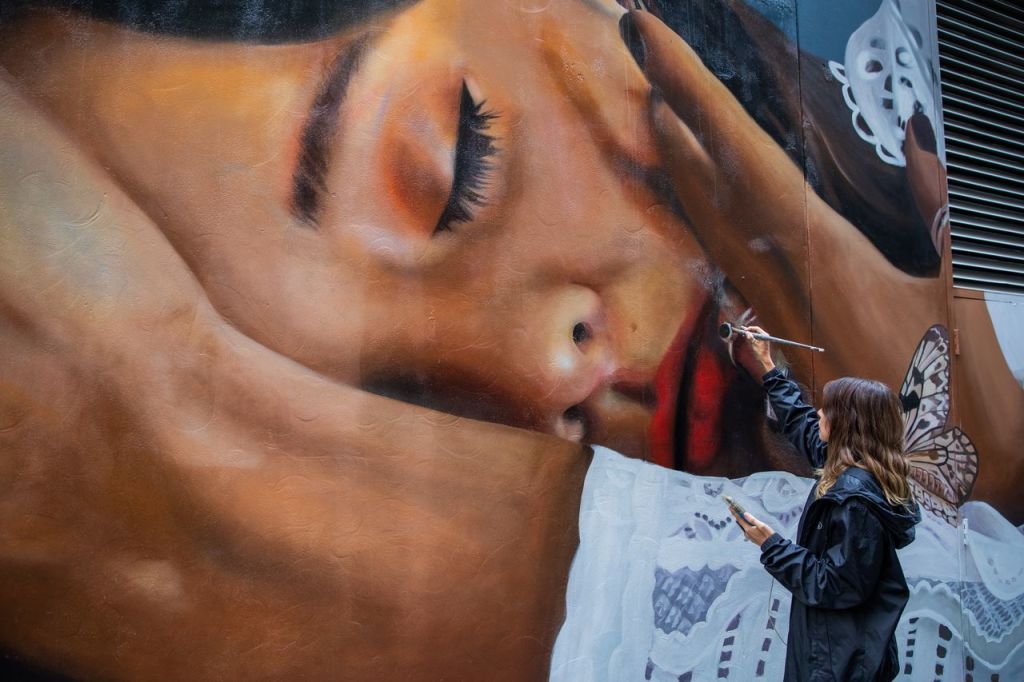 Graffiti artist Lisa King paints a large scale mural.