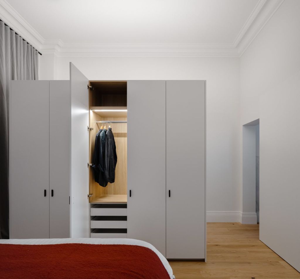 The bedroom is divided from the entry by custom-made cupboards. Photo: Katherine Lu