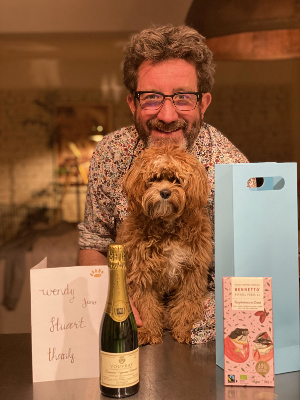 Wendy Rattray's husband Stuart and cavoodle Juno with their gifts from neighbours Lisette and Alissa. Photo: Supplied