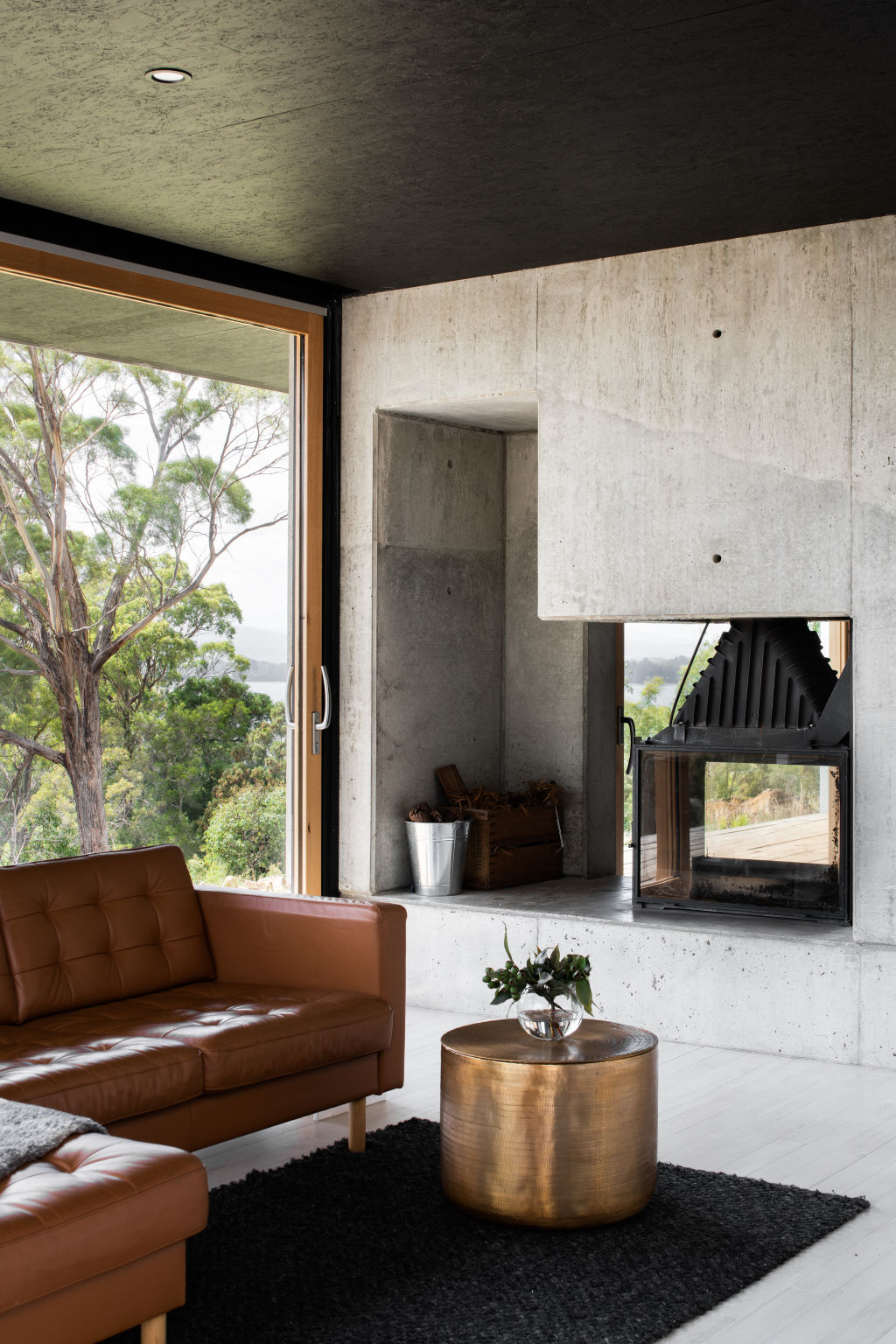 The concrete fireplace is inspired by the owners’ love of Japanese aesthetics and doubles as a room divider. Photo: Anjie Blair