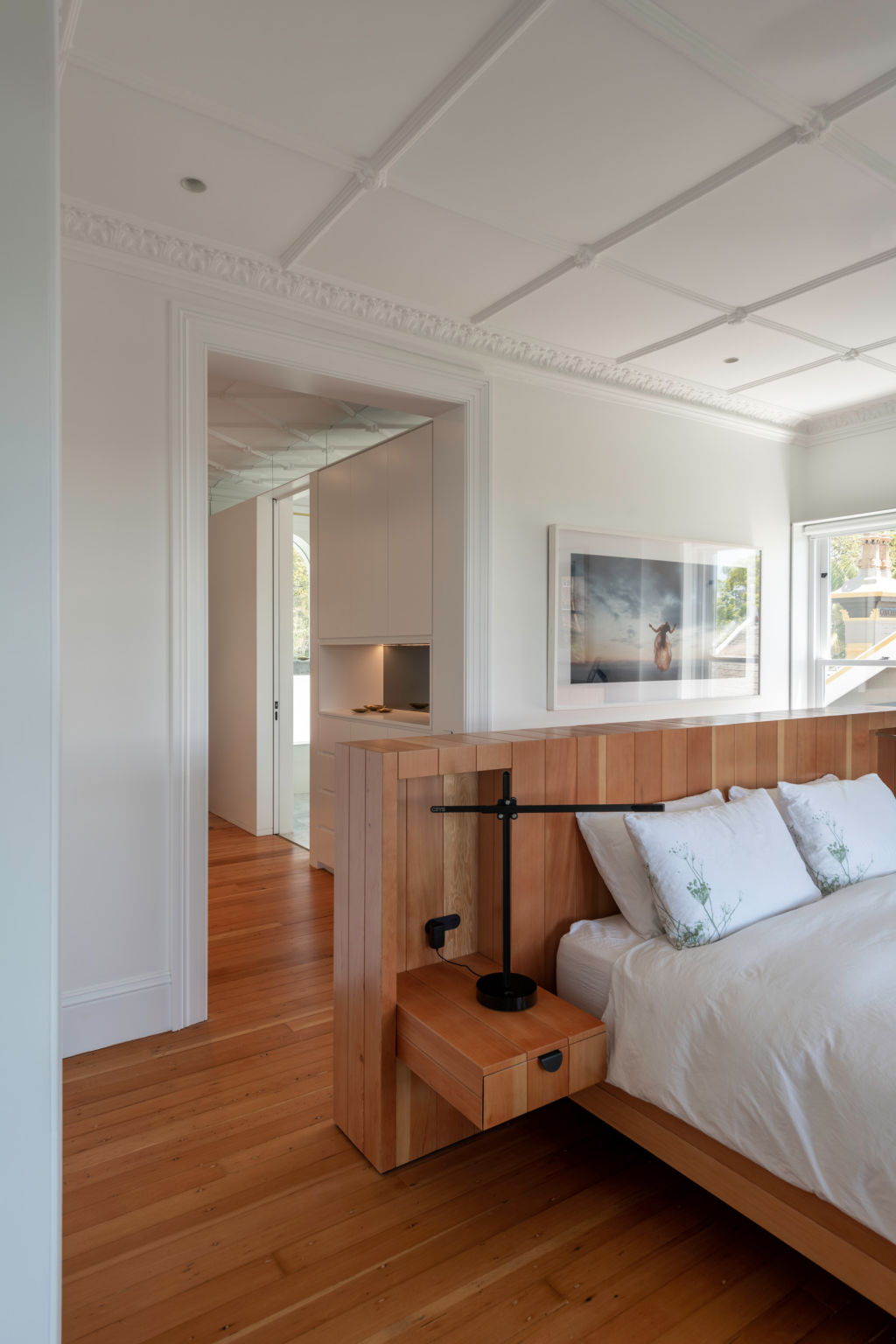 Behind the custom-made bedhead and between the wall and ceiling, a clerestory preserves the plasterwork. Photo: Willem Rethmeier